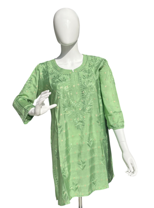 Green dress on a mannequin against a white background